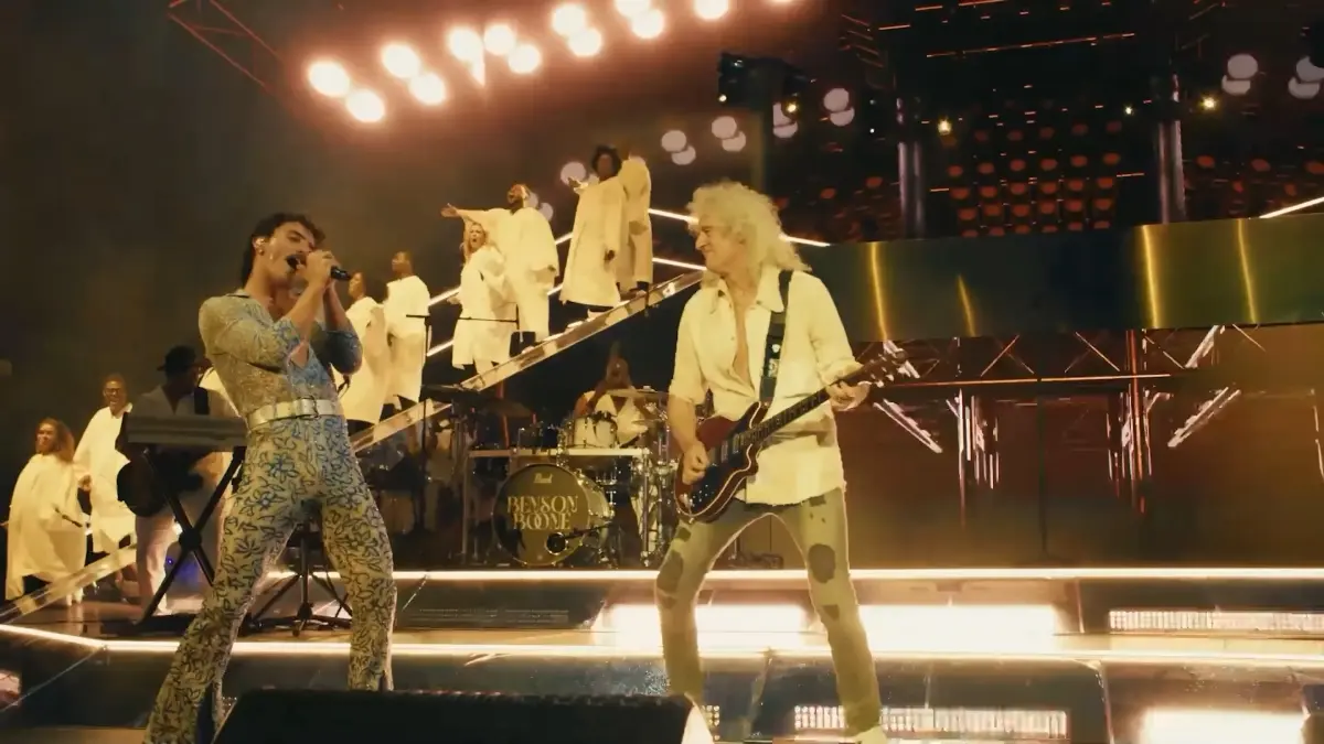 Benson Boone singing beside Brian May playing guitar onstage at Coachella 2025